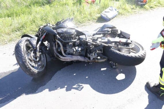 Beschädigtes Motorrad nach schwerem Unfall, Abschleppdienst, Einsatzkräfte, Unfallstelle auf kurviger Straße.