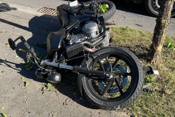 Motorradunfall in Bergneustadt: Verletzte Fahrerin auf Straße, Polizei ermittelt, Einsatzfahrzeug sichtbar.