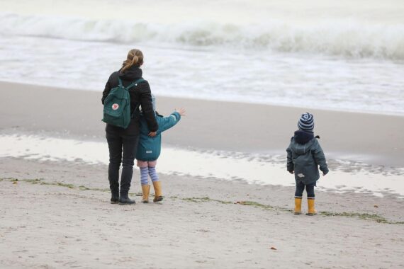 Selbstständige Frauen am Strand, symbolisch für Freiheit und die Herausforderungen während der Mutterschaft.