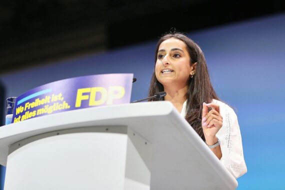 Nadin Zaya spricht auf dem Parteitag, umgeben von Zuschauern und Parteimitgliedern.