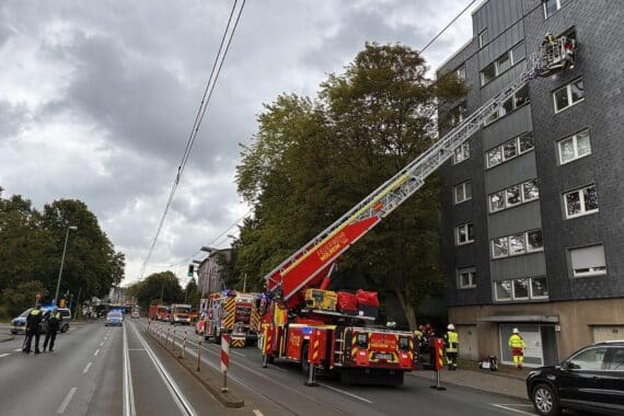 Feuerwehr rettet Person aus verrauchter Wohnung, Einsatzkräfte vor Ort mit Hochleistungslüfter.