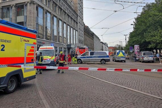 Auto in Menschenmenge, Polizei vor Ort, traurige Szene nach tragischem Vorfall in Leipzig.
