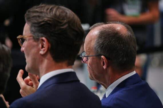 Politiker Hendrik Wüst und Friedrich Merz diskutieren über Kanzlertausch-Gerüchte in Berlin.
