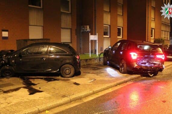 Schwerer Verkehrsunfall: BMW kollidiert mit geparkten Autos, erheblicher Sachschaden, Polizei vor Ort.