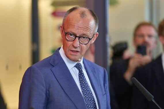 Friedrich Merz spricht, umgeben von Unionsabgeordneten, bei einer politischen Diskussion in Berlin.