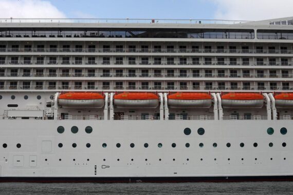 Kreuzfahrtschiff mit Rettungsbooten im Hafen, symbolisiert wachsenden Reisetourismus in Deutschland.