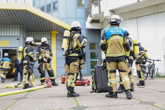 Feuerwehr im Einsatz, verrauchte Flure, verletzte Person nach Laborverpuffung an Universität.