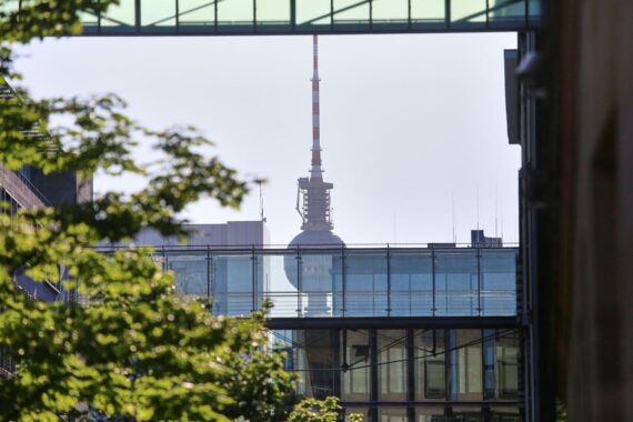 Sonniger Tag in Berlin, Fernsehturm vor blauem Himmel, warme Temperaturen, angenehmer Wind.