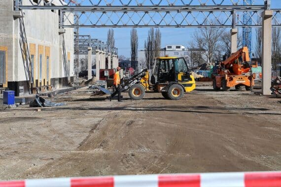 Bagger auf Baustelle, Unfallstelle, Handwerksarbeiten, medizinische Versorgung, Sicherheitsrisiko, verletzter Arbeiter.
