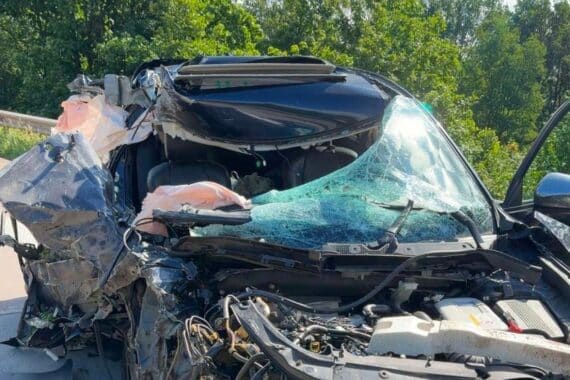 Verunfallter Mazda auf Autobahn, zusammengebrochenes Fahrzeug, Polizei und Rettungsdienst vor Ort.