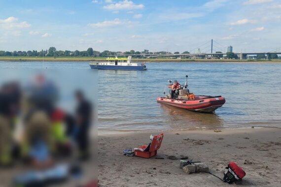 Rettungskräfte am Rheinufer, Einsatz wegen Badeunfall, Warnung vor Strömungsgefahren.