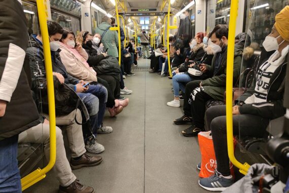Vollbesetzte U-Bahn während Corona-Pandemie, symbolisiert das Gesundheitsrisiko und fehlende Maskenverfügbarkeit.
