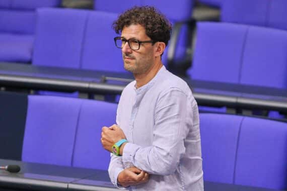 Luigi Pantisano bei einer Pressekonferenz, in hitziger Diskussion über politische Themen.