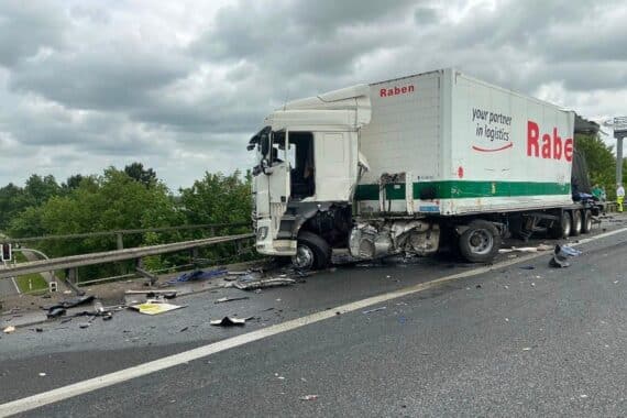 Zwei beschädigte Lkw nach Auffahrunfall auf Autobahn, Feuerwehr und Polizei im Einsatz.