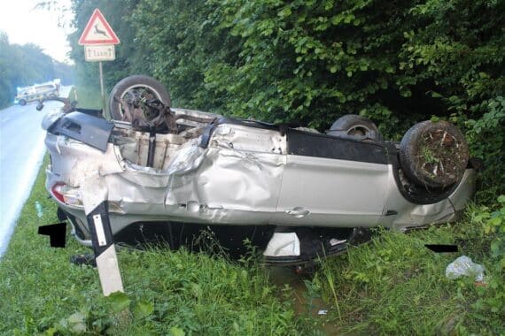 Verunfallte Autos im Straßengraben, Polizei und Rettungsdienst vor Ort, verletzte Personen.