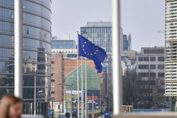 EU-Fahnen im Hintergrund, symbolisieren Einheit und Unterstützung der EU für die Ukraine.