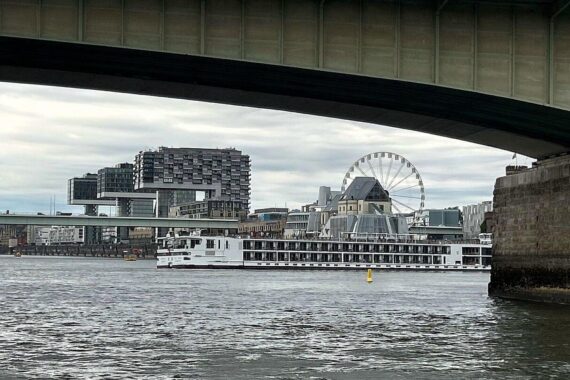 Ein festgefahrenes Fahrgastschiff auf dem Rhein, Kaimauer im Hintergrund, keine Verletzten.