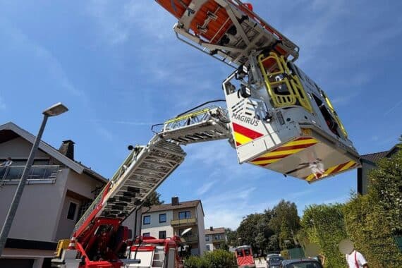Feuerwehr rettet Person mit Drehleiter aus Wohnung, medizinische Hilfe vor Ort.