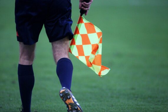 Linienrichter mit Fahne während eines spannenden Fußballspiels zwischen Saudi-Arabien und Uruguay.