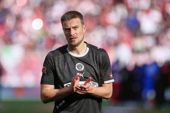 Hauke Wahl in Fußballtrikot, symbolisiert Wechsel zum VfL Wolfsburg, zeigt emotionale Verbundenheit.