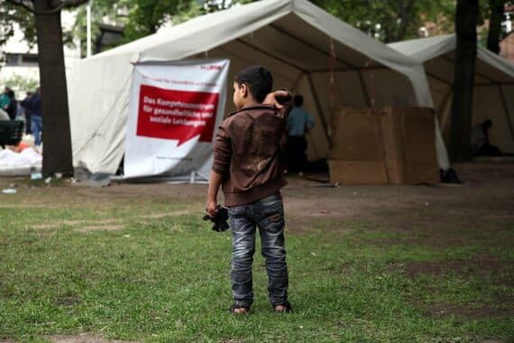 Flüchtlinge warten an einer Aufnahmestelle, unsichere Zukunft, Konflikt um Bleiberecht.