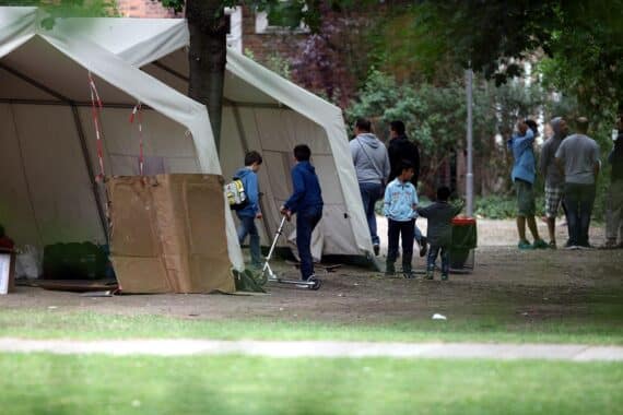 Flüchtlinge an einer Aufnahmestelle, symbolisiert die Herausforderungen der Asylverfahrensberatung in Deutschland.