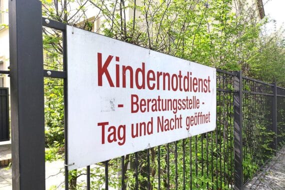 Bild zeigt sorgende Erwachsene mit Kindern, symbolisiert Schutz und Unterstützung für gefährdete Jugendliche.