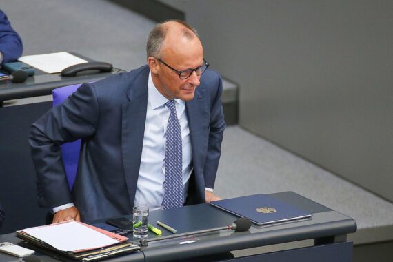 Friedrich Merz spricht während einer politischen Veranstaltung, umgeben von Parteimitgliedern und Anhängern.