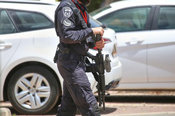 Ein israelischer Soldat patrouilliert angespannt, während Raketenangriffe aus dem Iran drohen.