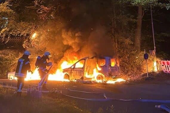 Brand eines VW Caddy, Feuerwehr löscht Feuer, angeschmolzene Mülltonne und Böschung.