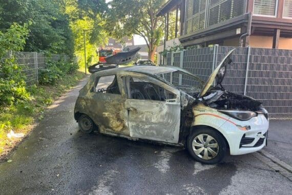 Ausgebrannter Pkw in Stuttgart, Feuerwehr im Einsatz, Übergreifen auf Gebäude droht.