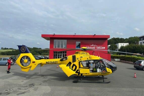 Ein Rettungshubschrauber landet auf Parkplatz, Feuerwehrkräfte unterstützen bei medizinischem Einsatz nach Unfall.