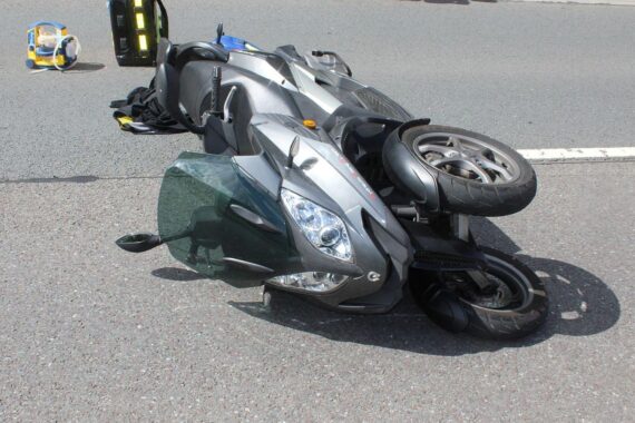Verunfallter Rollerfahrer auf der Straße, erkennbar durch die Unfallspuren und den Roller.