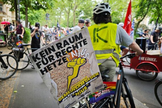 Fahrraddemonstranten in Berlin protestieren gegen rechte Medienportale mit Transparenten und Skandalen.