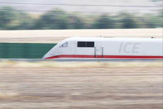 ICE-Zug im Fokus, während Verkehrsminister Schnieder über Bahnzuverlässigkeit und Infrastrukturmodernisierung spricht.