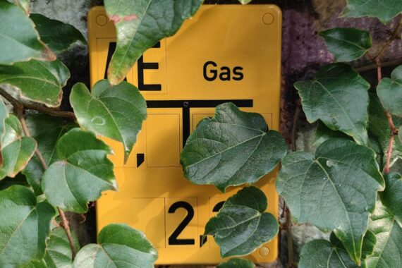 Gas-Hinweisschild vor Fracking-Bereich, symbolisiert potenzielle Erdgasressourcen und Herausforderungen in Deutschland.