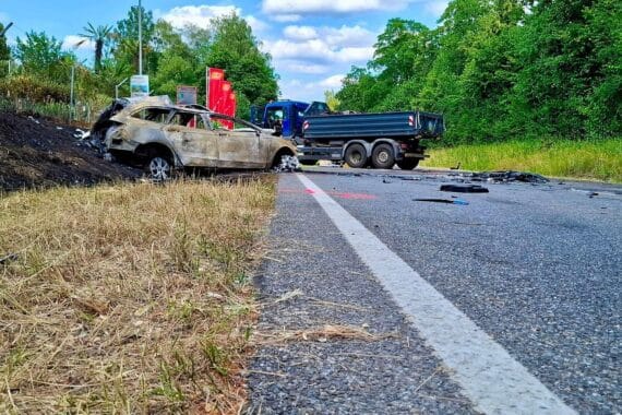 Ein Unfall mit Pkw und Lkw, Feuerwehr beim Löschen, Einsatzkräfte und Trümmer.