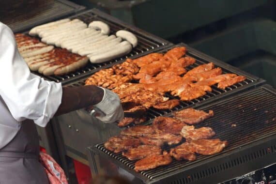 Grill mit Hähnchenschnitzel und Würsten symbolisiert weltweit steigenden Fleischkonsum und Klimafolgen.