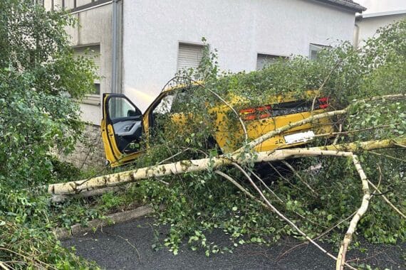 Ein verunglücktes Auto, umgestürzte Bäume und eine beschädigte Hauswand in Drabenderhöhe.