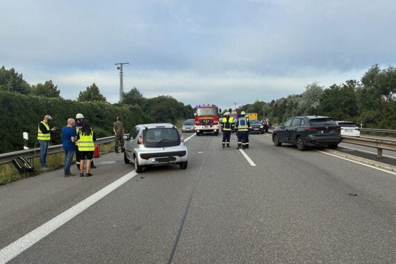 Autobahnunfall mit drei Fahrzeugen, erheblichem Schaden und Verkehrsbehinderungen, Feuerwehr und Polizei im Einsatz.