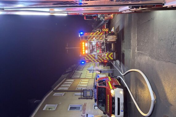 Brand in Mehrfamilienhaus in Schweinfurt, Feuerwehr rettet Bewohner, Flammen schlagen aus Fenster.