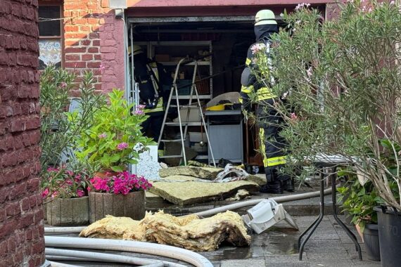 Feuerwehr löscht Garagenbrand, zwei Verletzte, starke Hitzeentwicklung im Hinterhof eines Wohngebäudes.