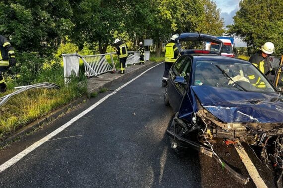 Verunfallter VW Polo an Brücke, Feuerwehr und Rettungsdienst vor Ort, schwere Schäden sichtbar.