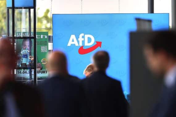 AfD-Logo auf Parteitag mit aktuellen Umfrageergebnissen und politischer Stimmungslage.