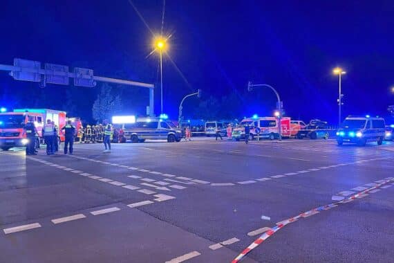 Auto bei CSD im Menschenstrom, Polizei und Rettungskräfte im Einsatz nach Kollision.
