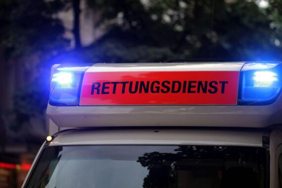 Automobilunfall mit Rettungsdienst, beschädigten Fahrzeugen und umgestürzten Anhänger an Kreuzung.