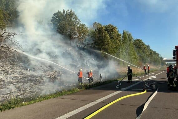Feuerwehr löscht ausgedehnten Vegetationsbrand an der Autobahn A5 nahe Offenburg.