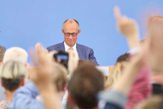Friedrich Merz bei der Sommerpressekonferenz, kritisiert von FDP und Linken; Deutschland, politisches Pressefoto.
