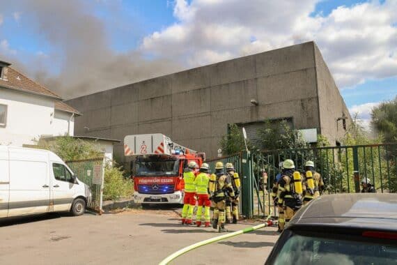 Feuerwehr im Einsatz bei Brand einer leerstehenden Lagerhalle in Essen-Altenessen-Süd, starke Rauchentwicklung, Rauchwolke.