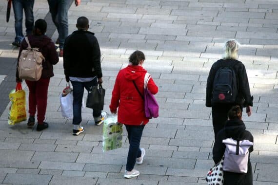 Menschen in der Fußgängerzone, unsicher über Reformen in Deutschland, besprechen wirtschaftliche Auswirkungen.